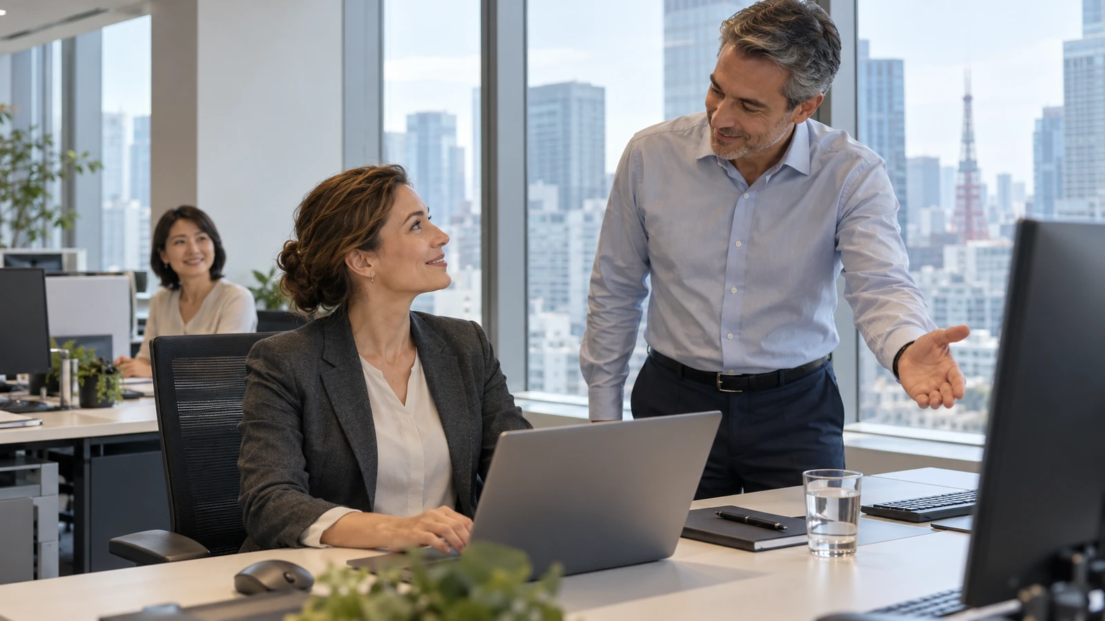 Illustrative scene of an experienced specialist being welcomed by colleagues at a prepared office workstation.